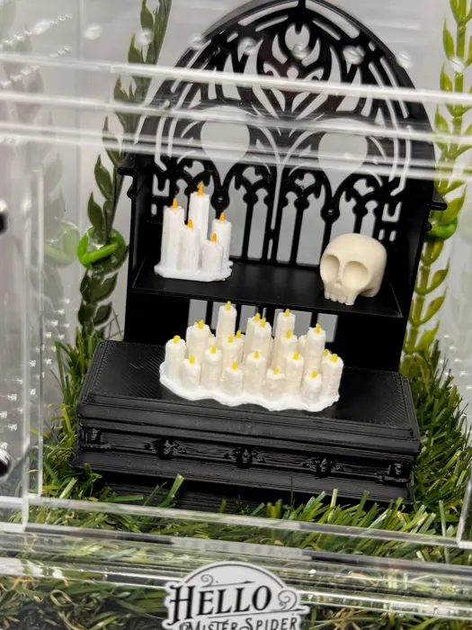 Arch enclosure with candles and a skull under an iron gate