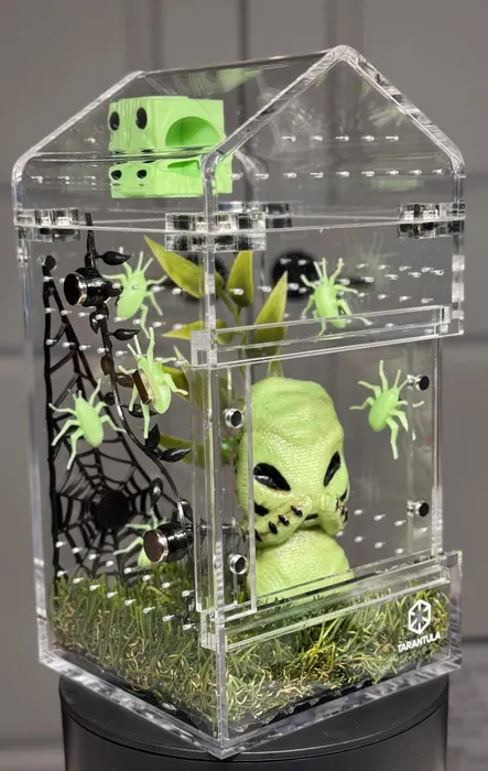 Enclosure with a green alien and spider webs